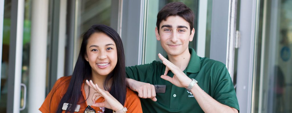 Two people displaying the whoosh hand symbol.